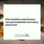 Selección de diez botellas de bebidas espirituosas con personalidad, como whisky, mezcal y absenta, dispuestas en una elegante barra de bar de madera.