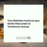 Primer plano de tres bebidas icónicas en tendencia: un cóctel de absenta, un vermut rojo y un combinado de licor de café en una barra elegante.